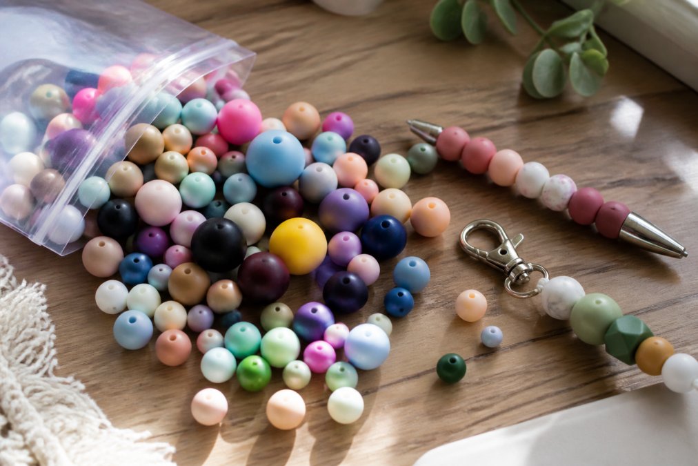 Comparison chart of bulk silicone beads in various colors and sizes displayed with finished craft projects.