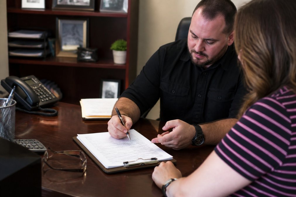 Bail bondsman explaining release paperwork to a client, helping compare Bulldog Bail Bonds vs Caprock services.