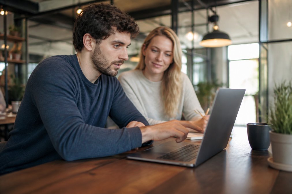 Smartphone en desktop-monitor naast elkaar, beide tonen dezelfde website met snel geladen afbeeldingen en snelle laadtijdweergave, moderne werkplek