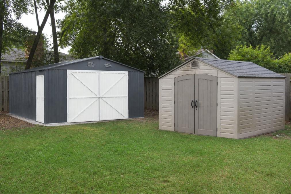 Residential backyard showing a galvanized metal storage shed on one side and a resin plastic storage shed on the other, both weathered by seasons with visible patina and environmental exposure, demonstrating material durability differences under real-world conditions