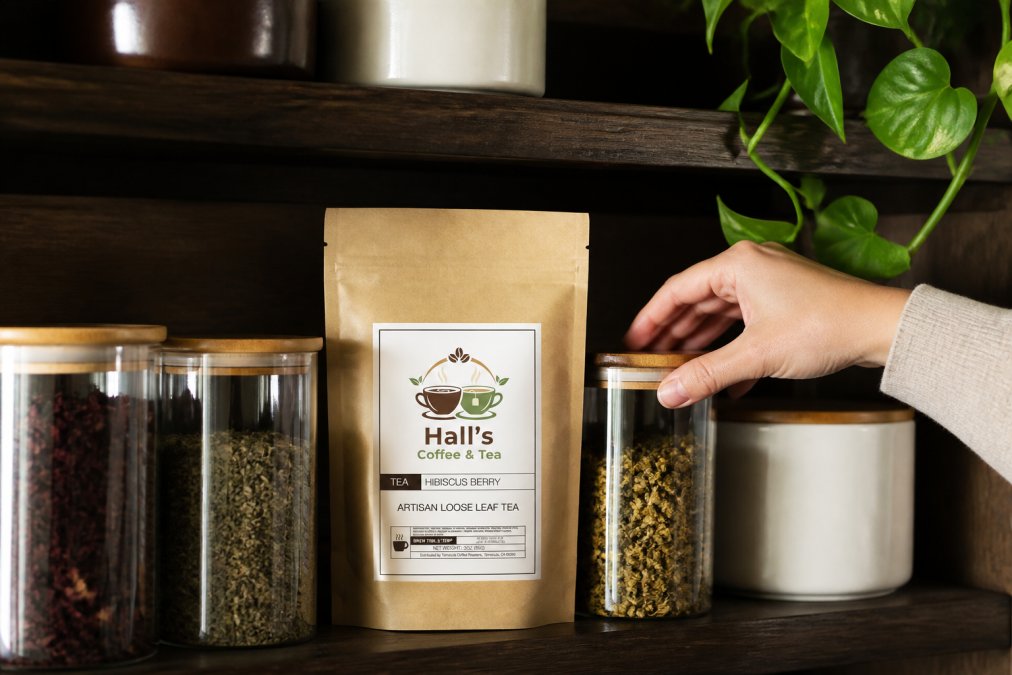 Close-up of a hand reaching for one of several glass and ceramic tea storage containers arranged on a dark wooden shelf, whole leaf tea visible through the clear glass sides, soft diffused indoor lighting