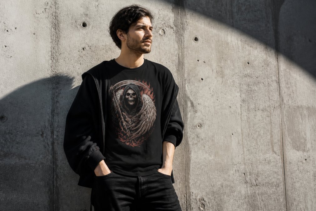 Person in a black graphic streetwear t-shirt standing against a textured concrete urban wall