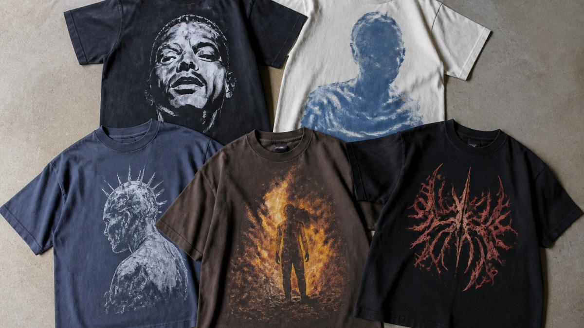 Flat lay of five graphic tees arranged on neutral background, each displaying distinct designs and colors, showing print detail and heavyweight fabric texture