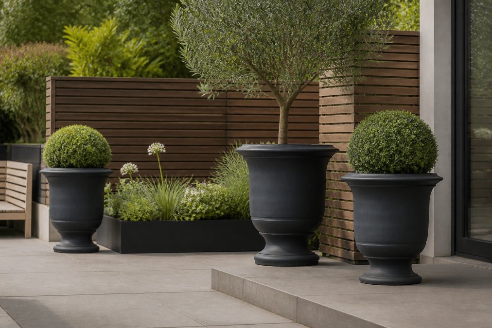 Modern patio garden featuring large statement urns arranged asymmetrically with contemporary architectural elements, horizontal timber screening, and carefully curated plantings creating defined zones
