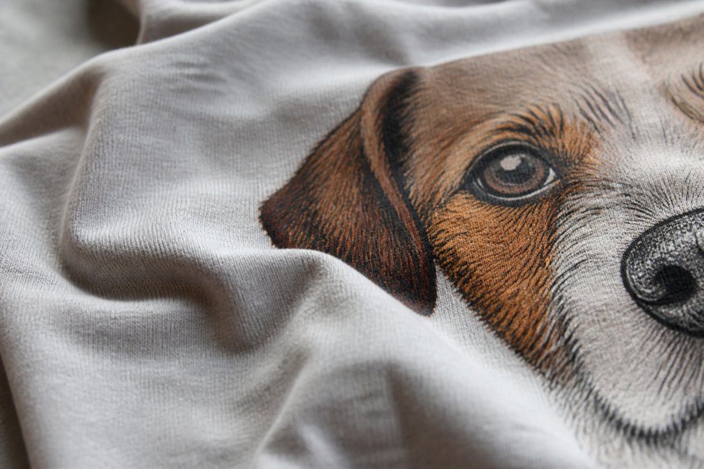 Close-up of soft, high-quality cotton fabric with dog graphic design visible, showing texture and print detail with natural lighting
