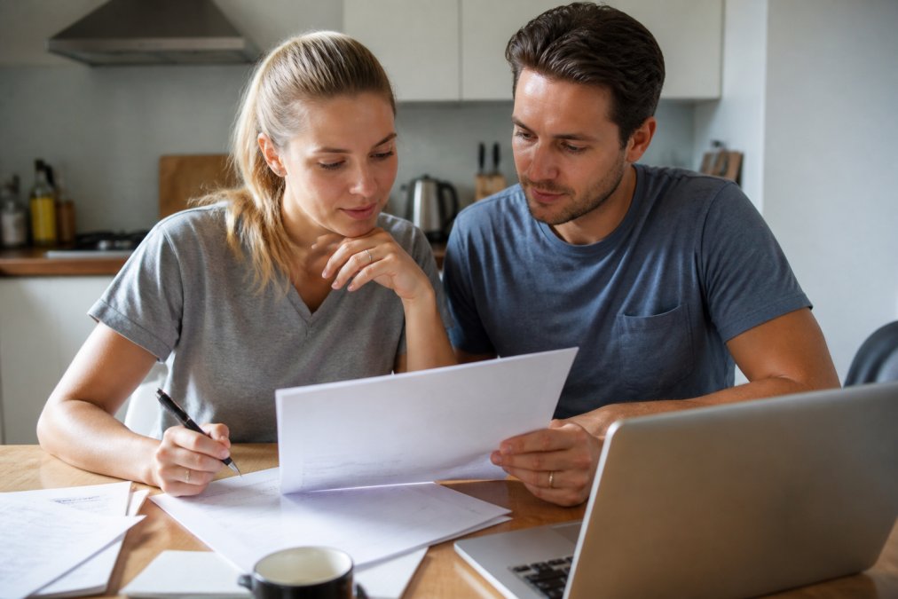 Flowchart showing a first-time buyer couple comparing solicitors fees and hidden costs on a document.