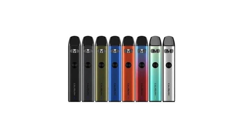 Close-up of several UWELL Caliburn vape devices arranged on a clean surface showing the compact sleek design from different angles with natural lighting