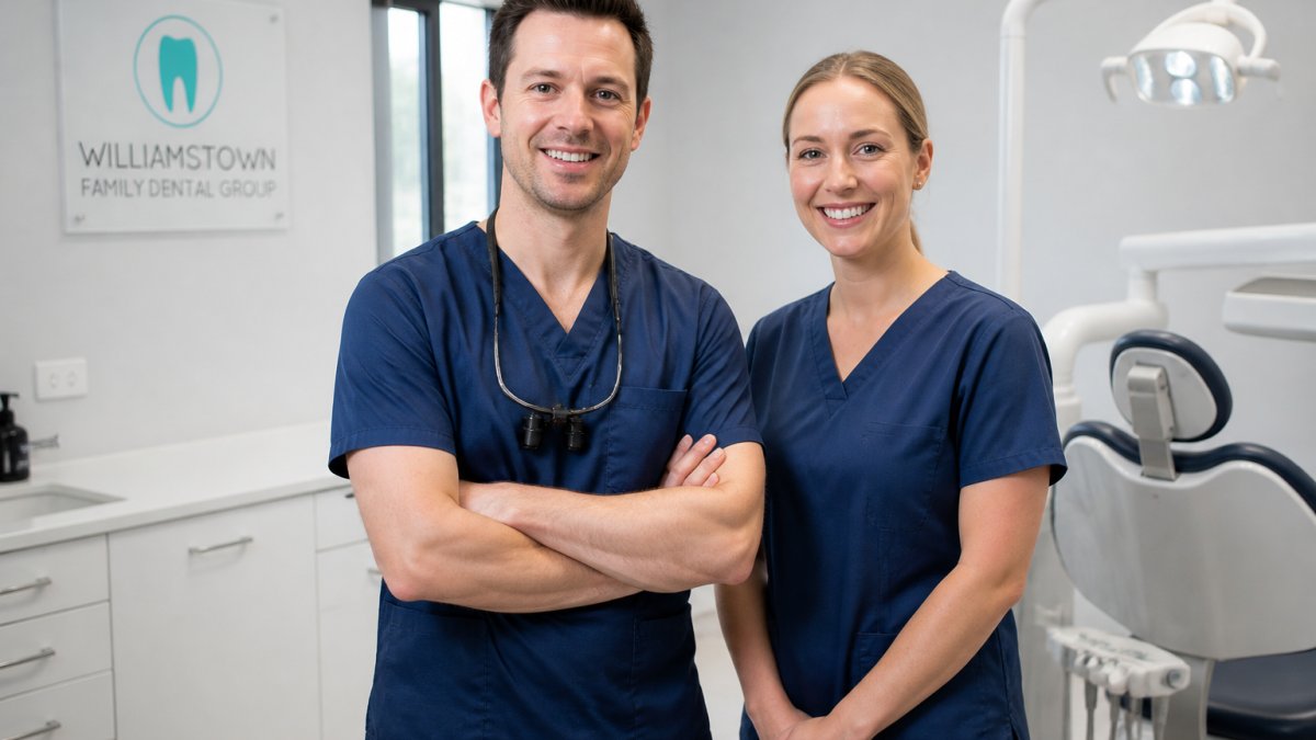 Professional dental team in modern clinical setting with dental chair and contemporary equipment, dentist and dental nurse smiling in professional attire in warm, welcoming surgery