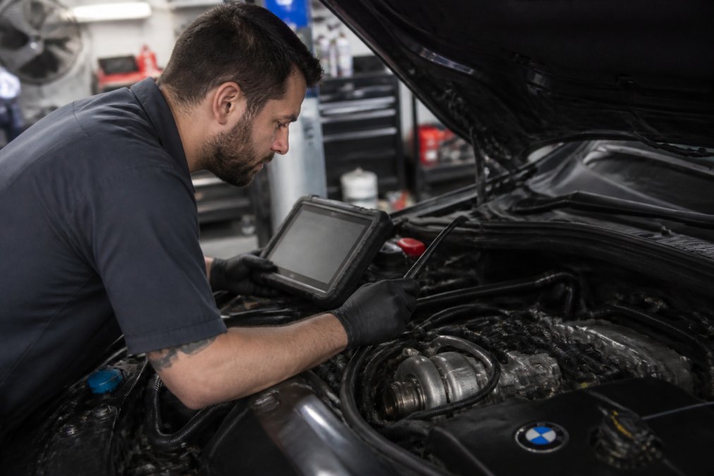 ASE-certified mechanic performing a diagnostic scan for turbo service near me on a BMW engine