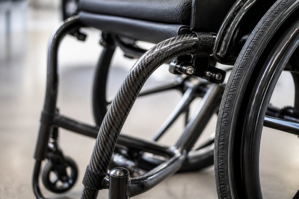 Close-up of a carbon fibre wheelchair frame showing its smooth, refined finish and structural integrity under professional lighting