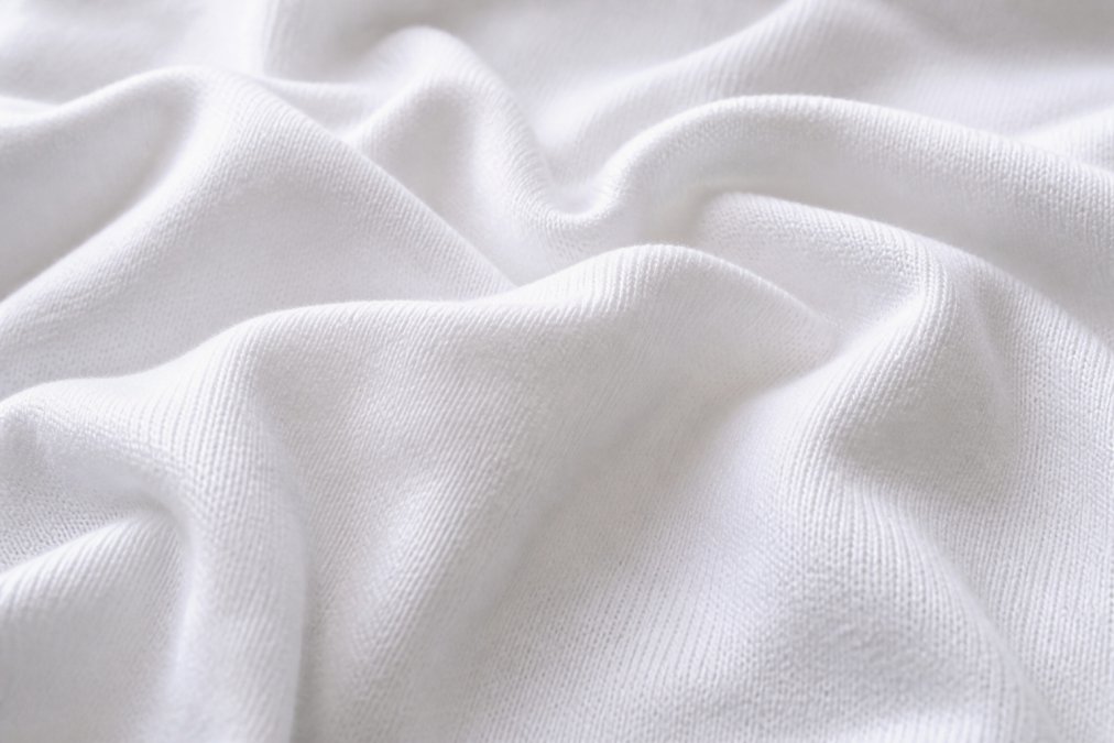 Close-up of premium cotton fabric texture showing tight weave construction and fiber detail under natural lighting
