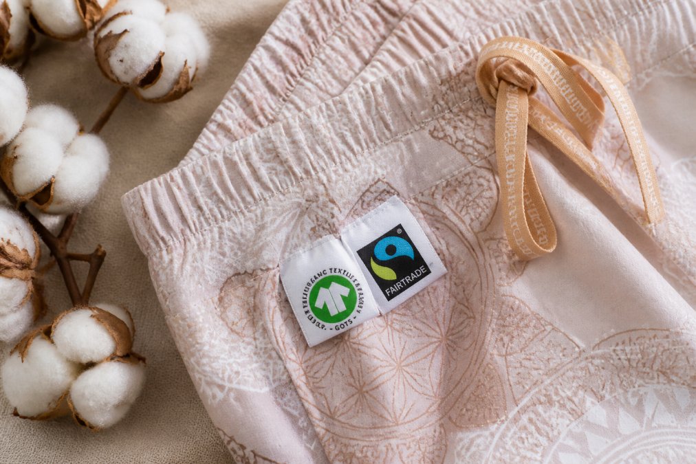 Detailní záběr na certifikované štítky GOTS a fair trade na oblečení z materiálu certifikovaná biobavlna s viditelnou