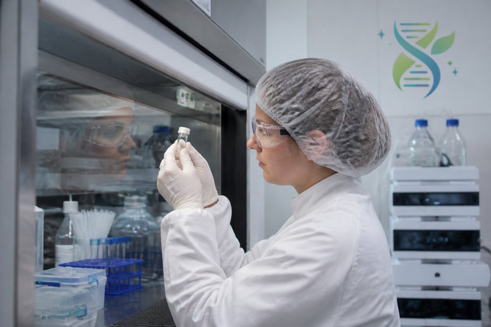 Scientist inspecting a vial during cGMP peptide manufacturing in a controlled laboratory environment
