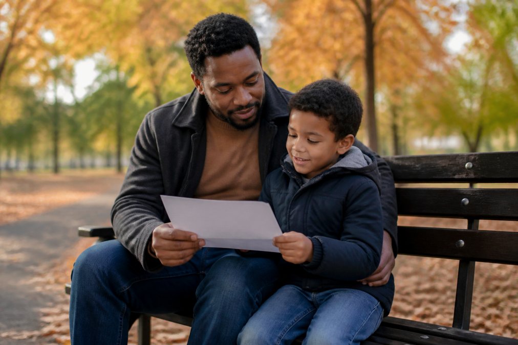 A parent and child reviewing documents on a park bench as Maryland child custody laws are considered.