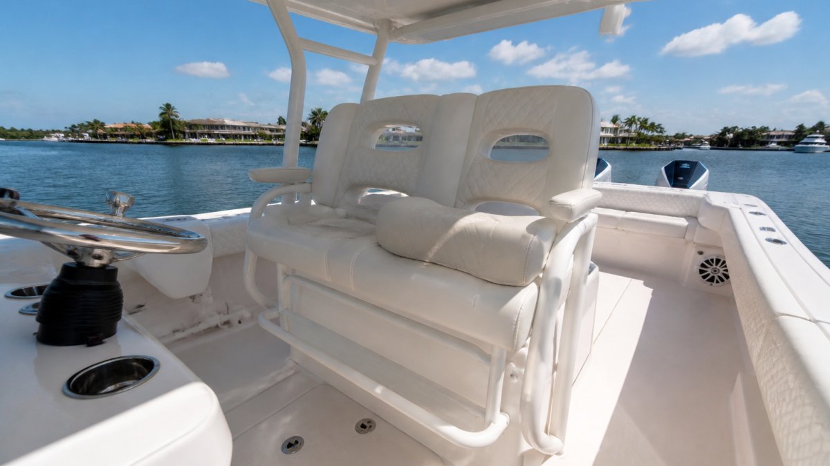 Wide-angle view of a center console boat's helm station showing the helm seat and bolster facing forward, passenger seating area to the side, and sun exposure across all surfaces during bright daylight