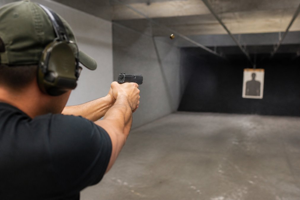 Shooter practicing rapid follow-up shots with a subcompact concealed carry caliber pistol at an indoor range