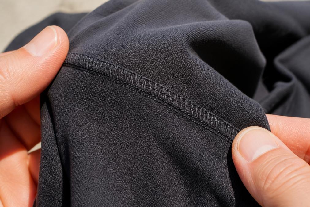 Close-up of quality stitching on a comfortable protest shirt seam showing reinforced thread under natural light