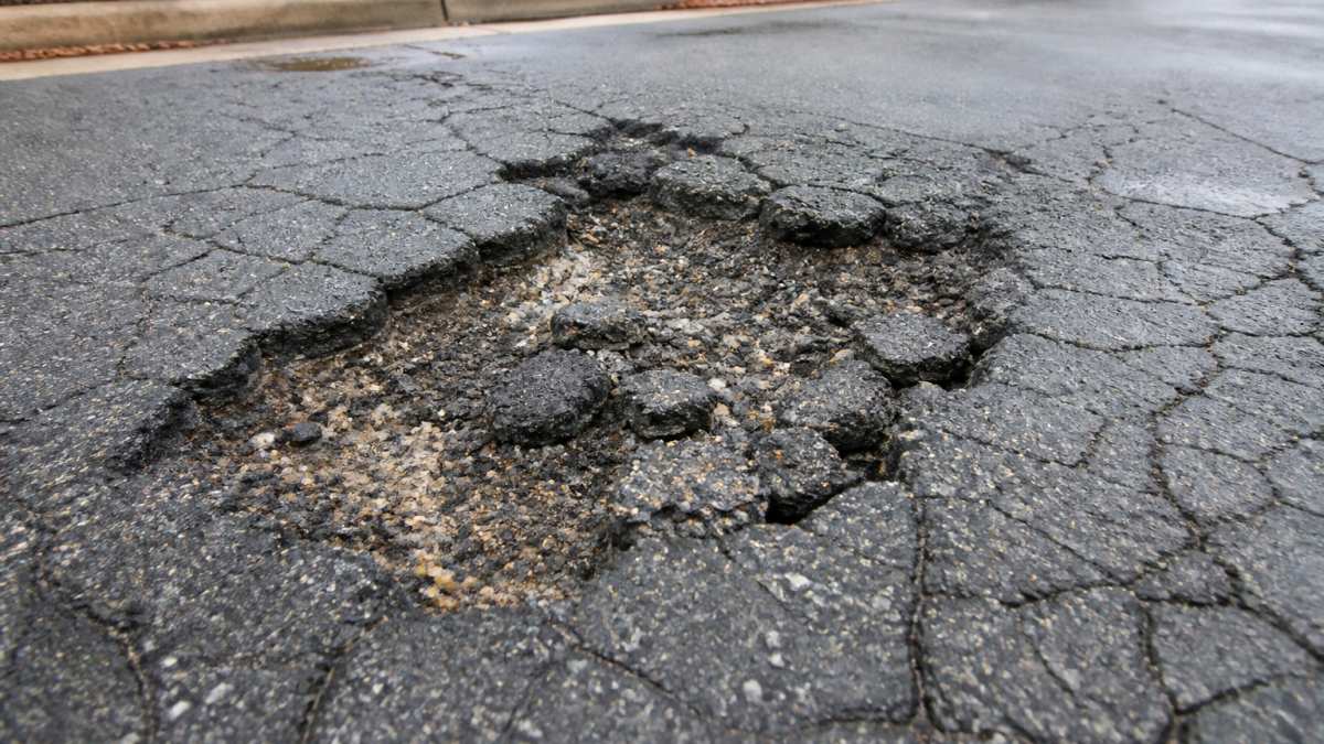 Infographic showing how asphalt patching cost factors relate to specific types of commercial pavement damage.