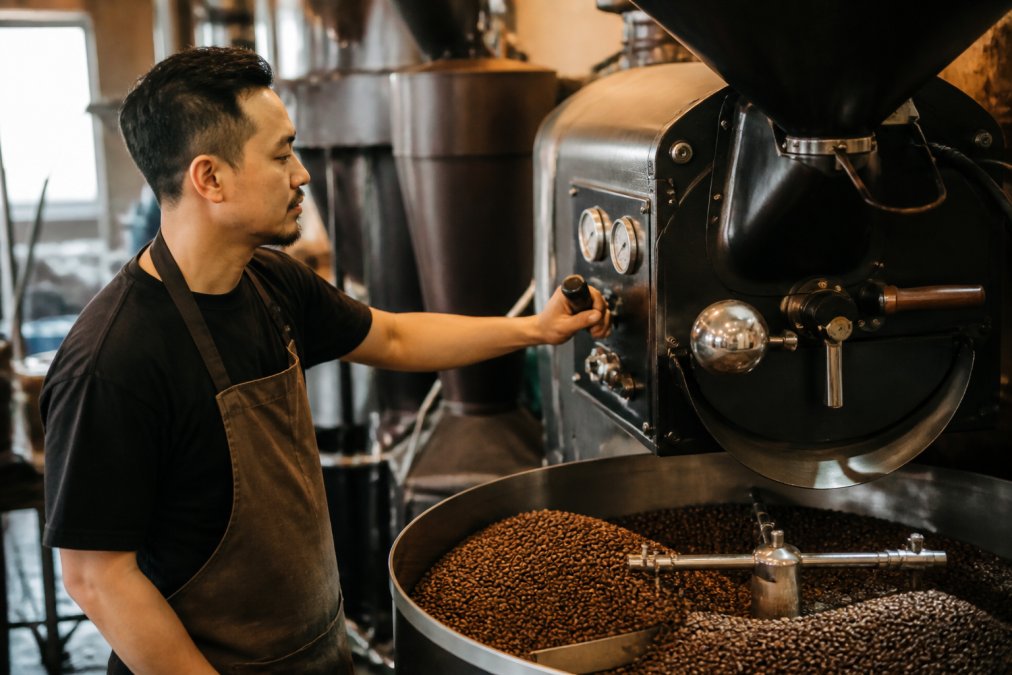 Roaster operator monitors temperature gauges during commercial coffee roasting in a professional facility