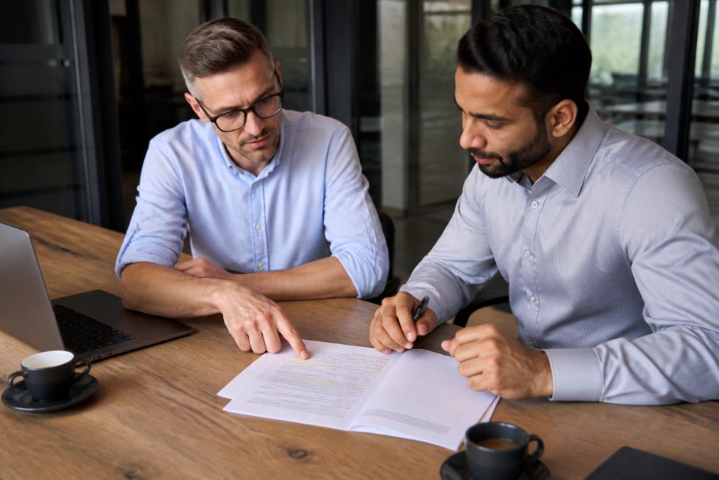 Professionals reviewing a commercial lease agreement common pitfalls checklist at a table.