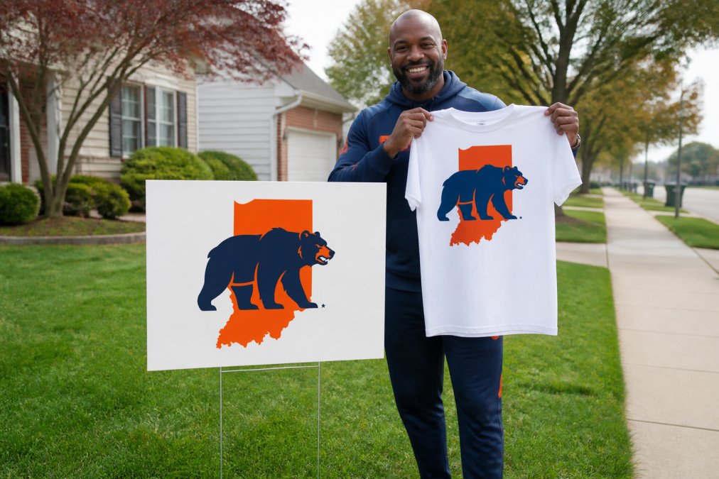 Community member proudly holding branded Indiana Bears t-shirt and yard sign, displaying the merchandise with genuine pride while standing in front of local neighborhood backdrop, natural daylight