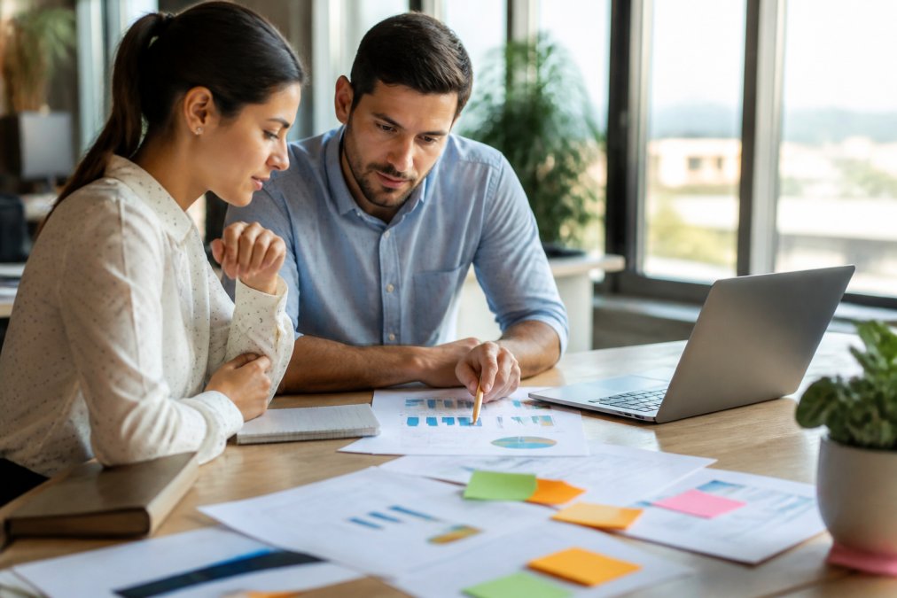 Dos profesionales analizan métricas en un portátil para identificar la pérdida de leads en el embudo de ventas.
