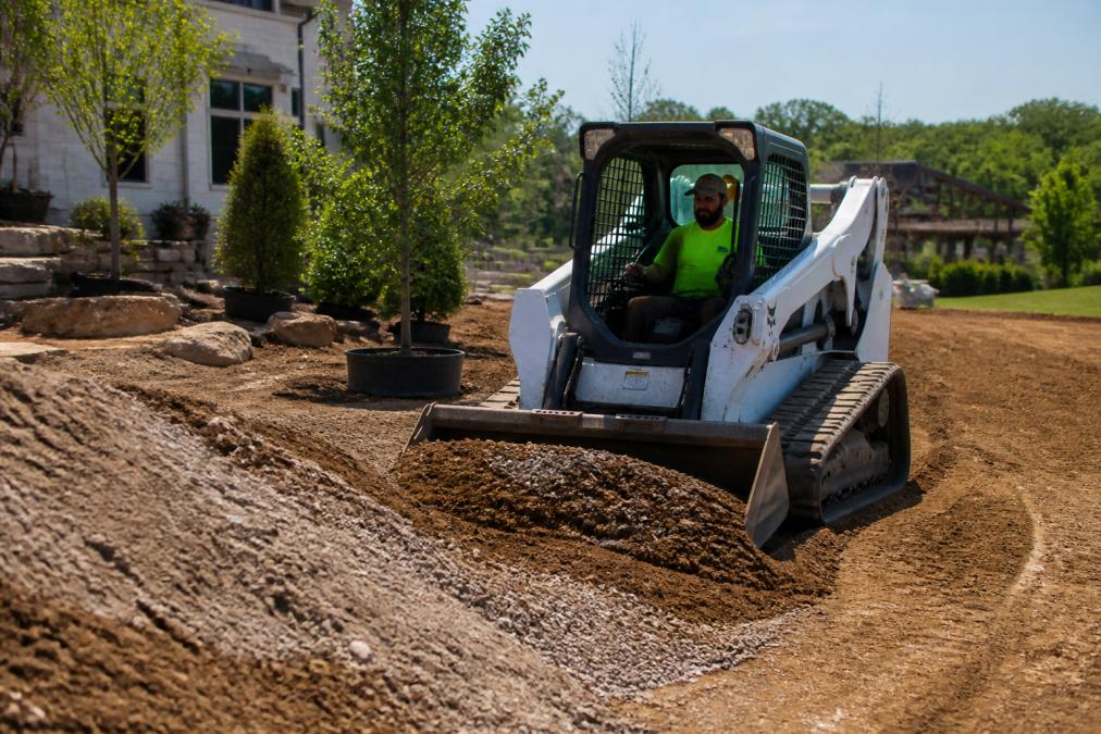 Landscaper operating a compact track loader for financing projects on a residential site