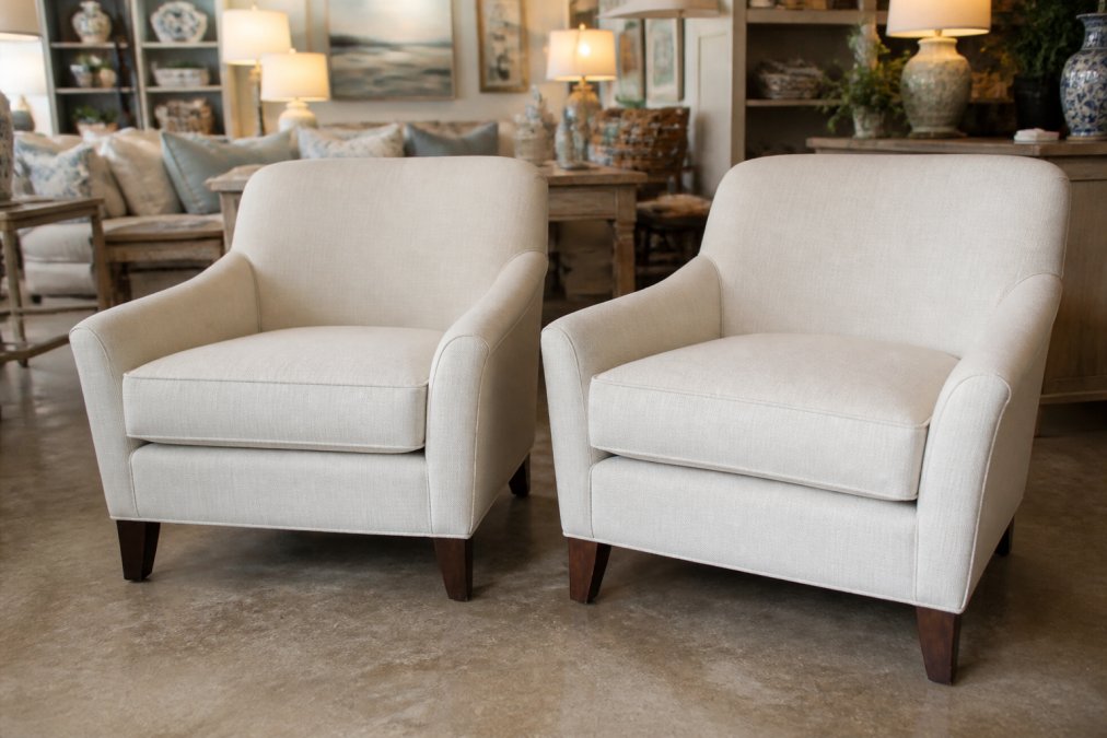 Customer browsing curated vintage and pre-loved furniture pieces in consignment showroom with room vignettes displaying furniture in realistic home settings