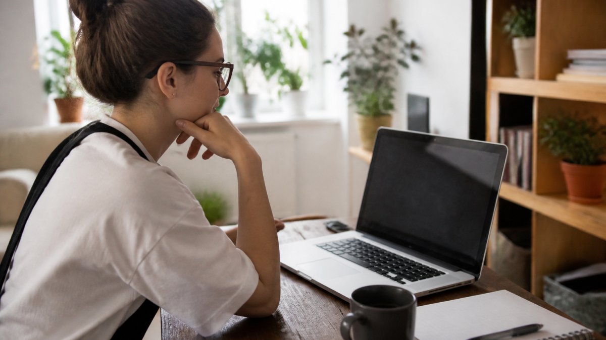Small business owner analyzing sales funnel data to convert prospects into customers on a laptop at home