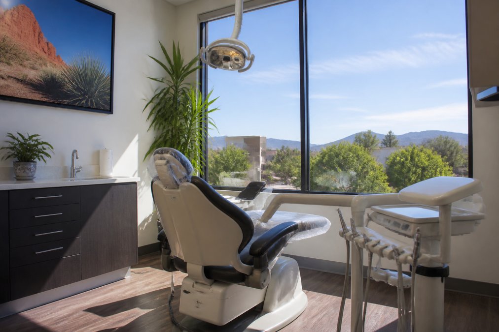 Professional dental office interior with modern equipment and a welcoming treatment room, showing a comfortable patient environment with natural lighting and advanced technology