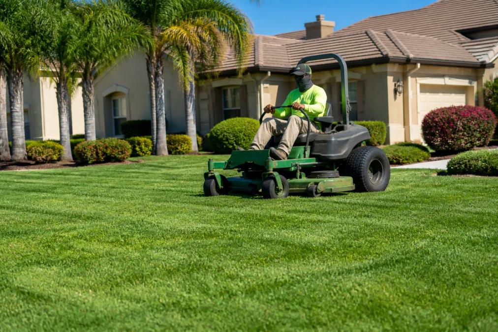 Professional landscaper using a zero-turn mower for lawn mowing Elk Grove on a sunny residential property