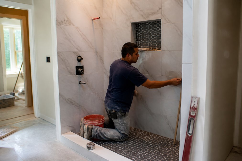 Infographic showing the labor and material breakdown for the cost to replace shower systems and tile work.