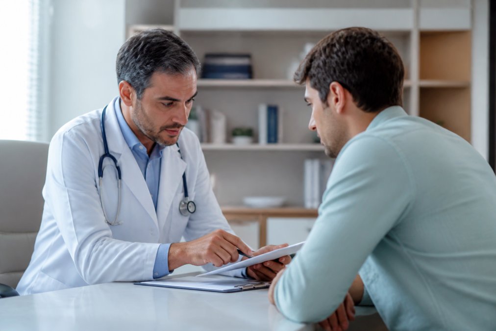 Médico explicando el costo de tratamiento prep privado a un paciente en una consulta confidencial dentro de una clínica