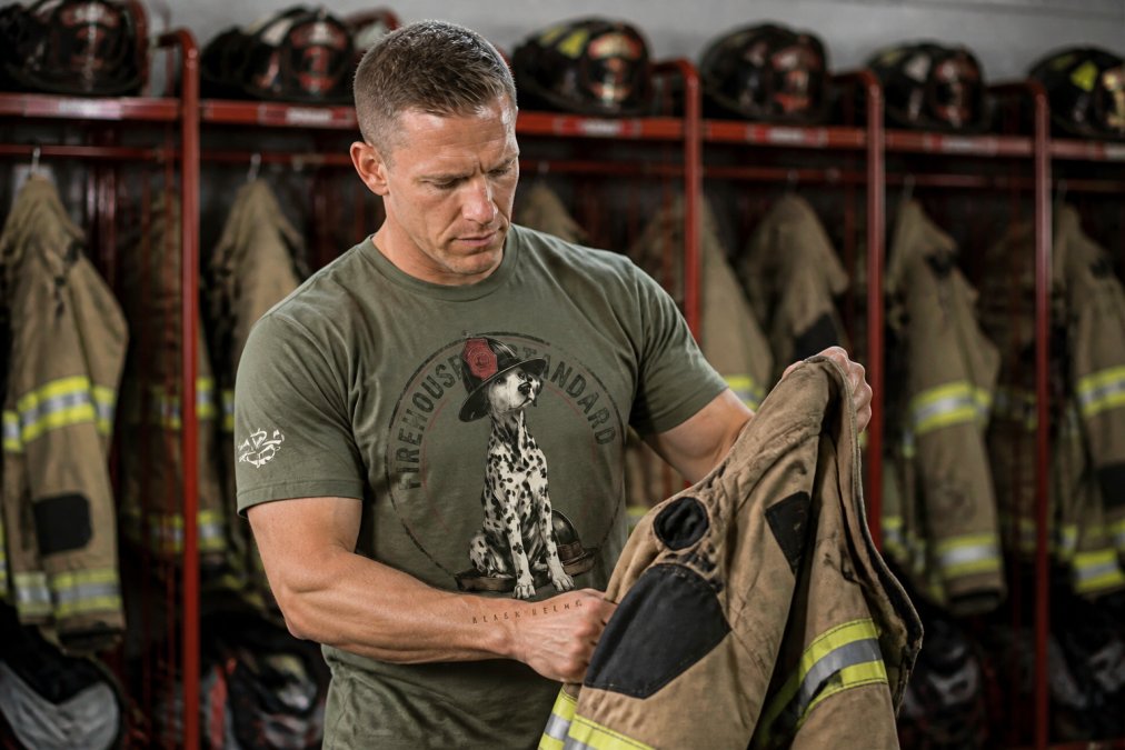 Firefighter in station environment wearing a well-maintained cotton blend shirt, showing practical durability and fit during routine duties in a busy firehouse
