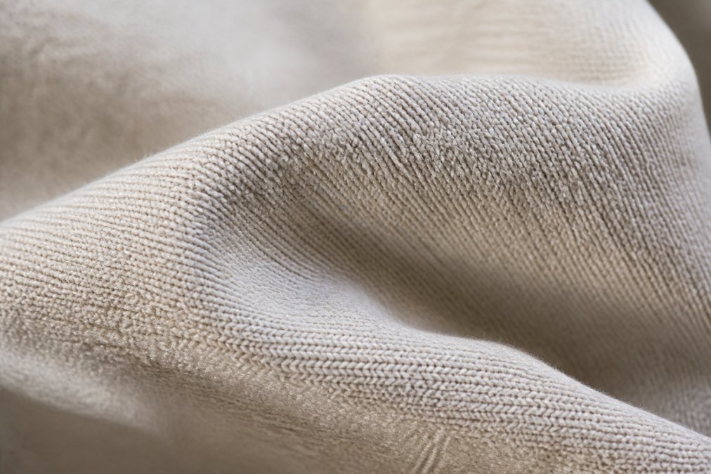 Close-up detail shot of heavy-weight cotton fabric texture and weave, showing the dense fibre structure and quality with natural lighting