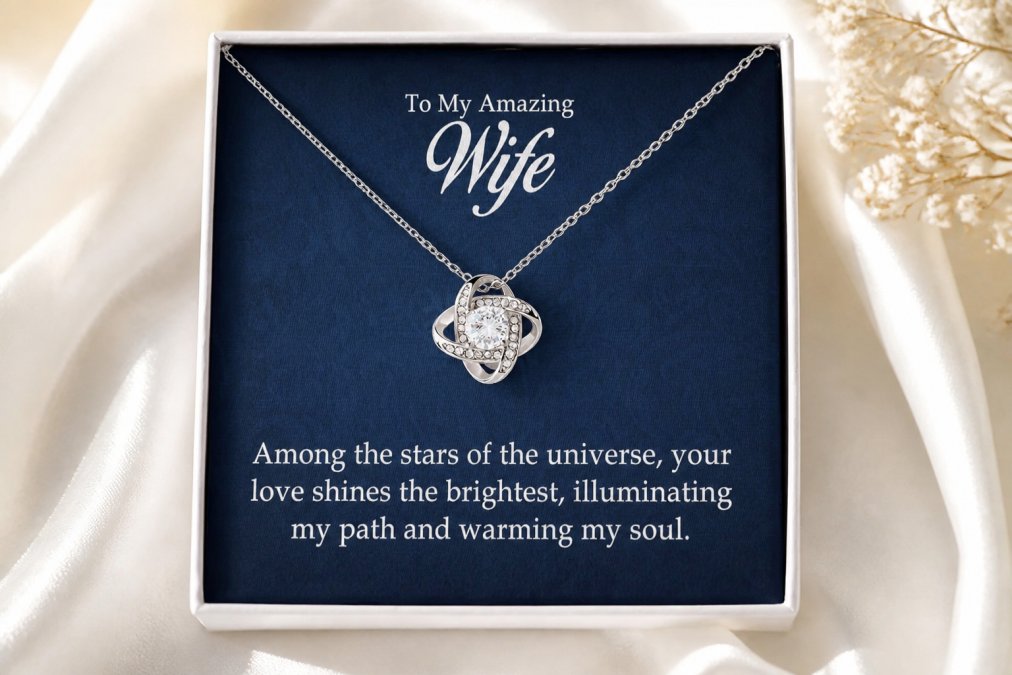 Close-up of elegant jewelry pieces including necklaces and bracelets with cubic zirconia crystals displayed on soft white fabric, crystals catching warm light from above