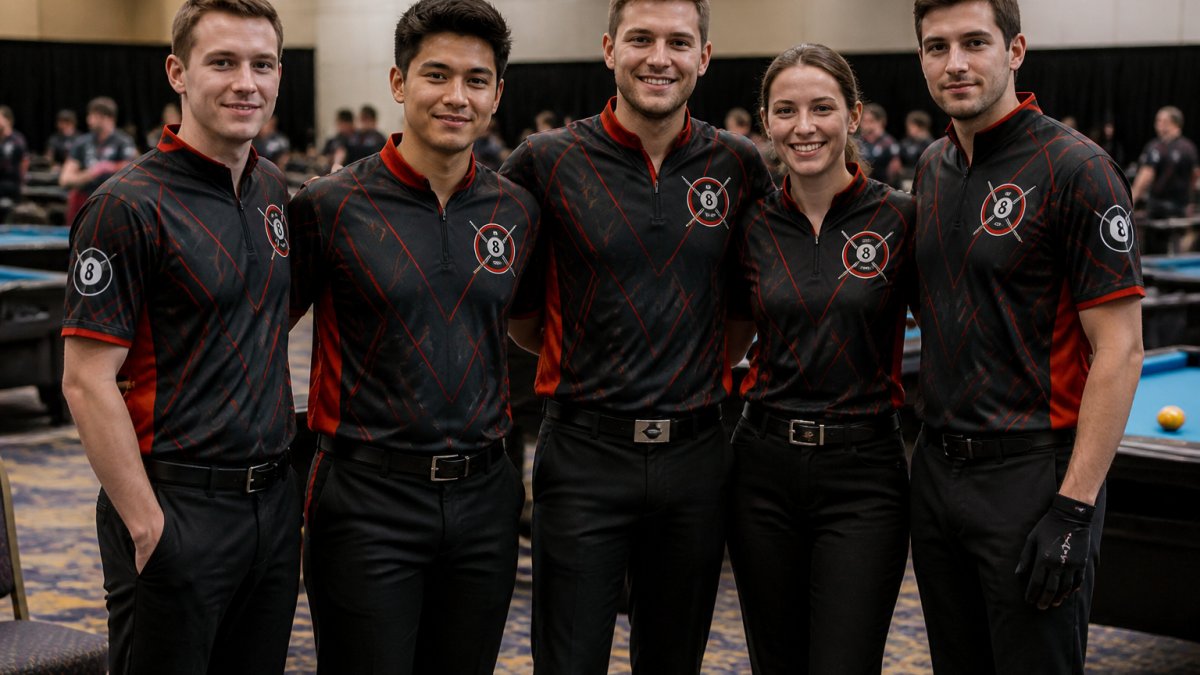 Competitive billiards team wearing matching custom jerseys with embroidered player names and team logo visible, posing together at a tournament venue with pool tables in background