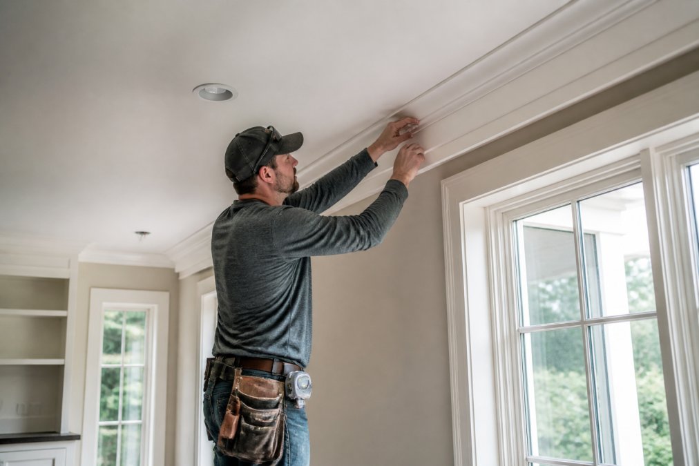 Infographic illustrating the process of custom carpentry vs general remodeling through crown molding installation.