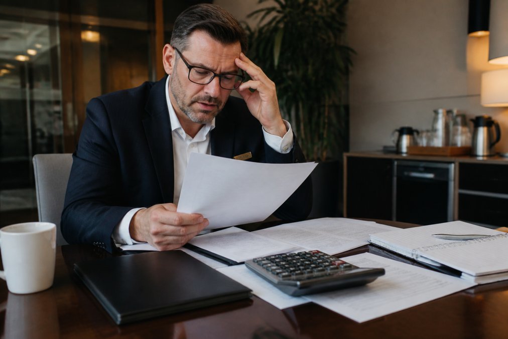 Hotel manager reviewing incident response documents to manage cyber insurance pricing for boutique hotels