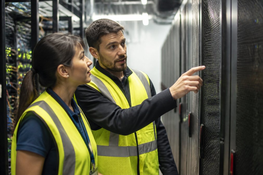 Data center manager reviewing real-time power monitoring dashboards in a server room