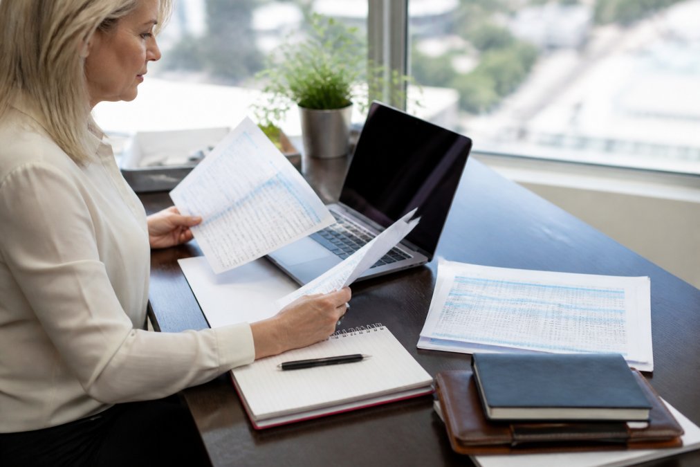 Professional reviewing dental and vision insurance provider networks on a laptop at a bright office desk