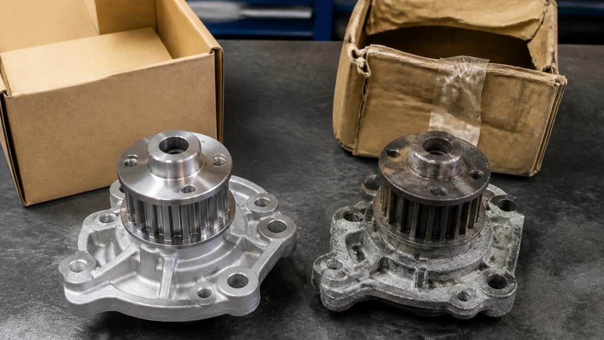 Close-up of genuine OEM part next to counterfeit version on workbench, showing packaging quality differences, label clarity, and physical finish details under bright work lighting
