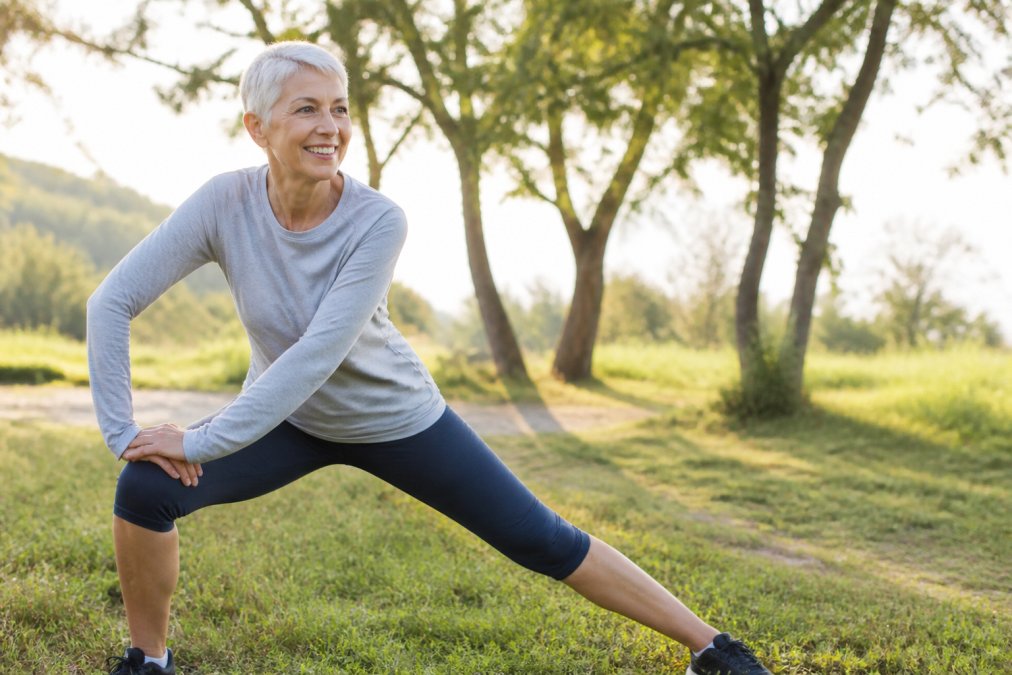 Active senior patient demonstrating improved mobility and flexibility, bending comfortably and stretching with ease, representing functional improvement and pain relief after regenerative treatment
