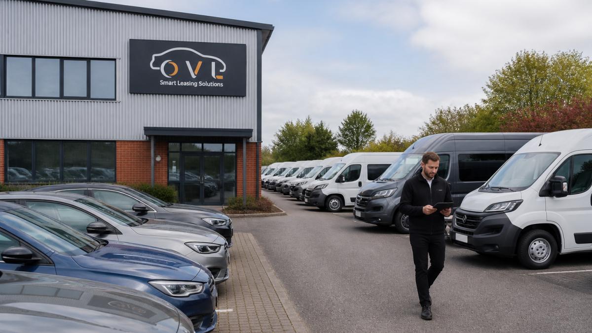 Professional fleet of modern cars and vans parked in structured fleet yard with office building visible in background, showing professional vehicle management setup