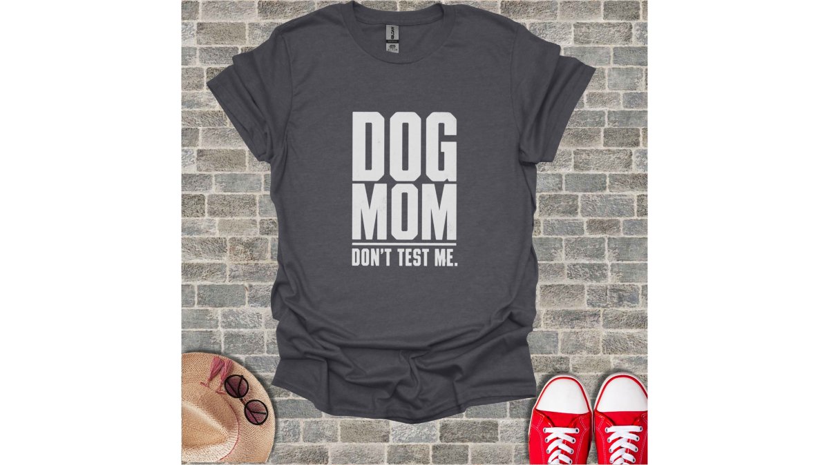 Close-up of a woman in a distressed-print graphic tee bending to clip a leash onto a golden retriever's collar outside a sunny suburban home