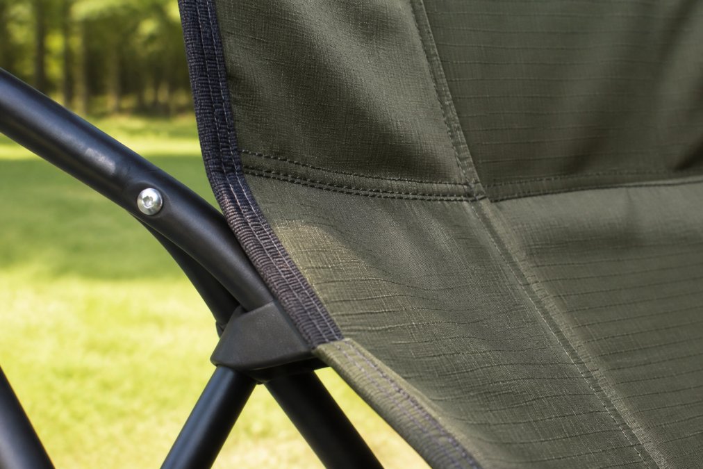 Close-up of a powder-coated steel frame and ripstop fabric on a camping chair, showing seam reinforcement and construction details in natural daylight