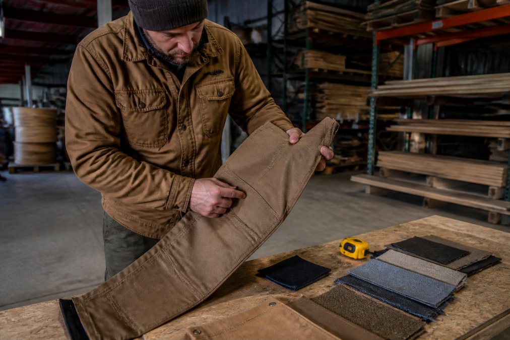 Infographic detailing the reinforced stitching and canvas fabric qualities that make work pants durable clothing.