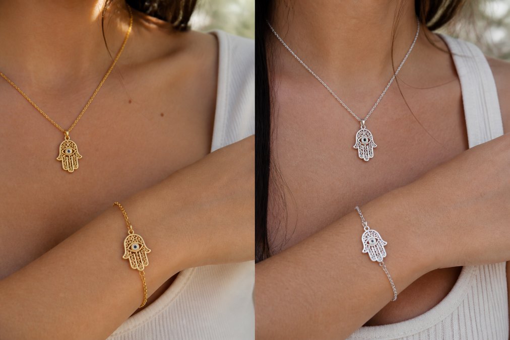 Close-up of a woman's wrist and neck wearing a gold-plated sterling silver hamsa necklace and bracelet, the fine details of the pendant catching warm natural daylight