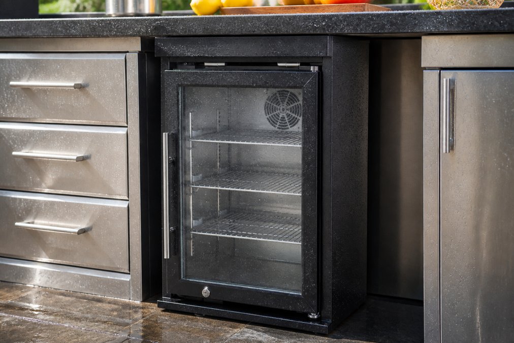 Close-up of stainless steel outdoor kitchen cabinet with water beading on the protective powder-coat finish, showing metallic sheen in natural sunlight
