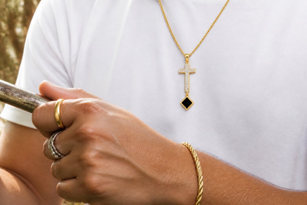 Close-up of hands wearing multiple pieces of polished gold-filled and sterling silver jewelry catching light during daily activities, showing the contrast between tarnished and bright metal finishes